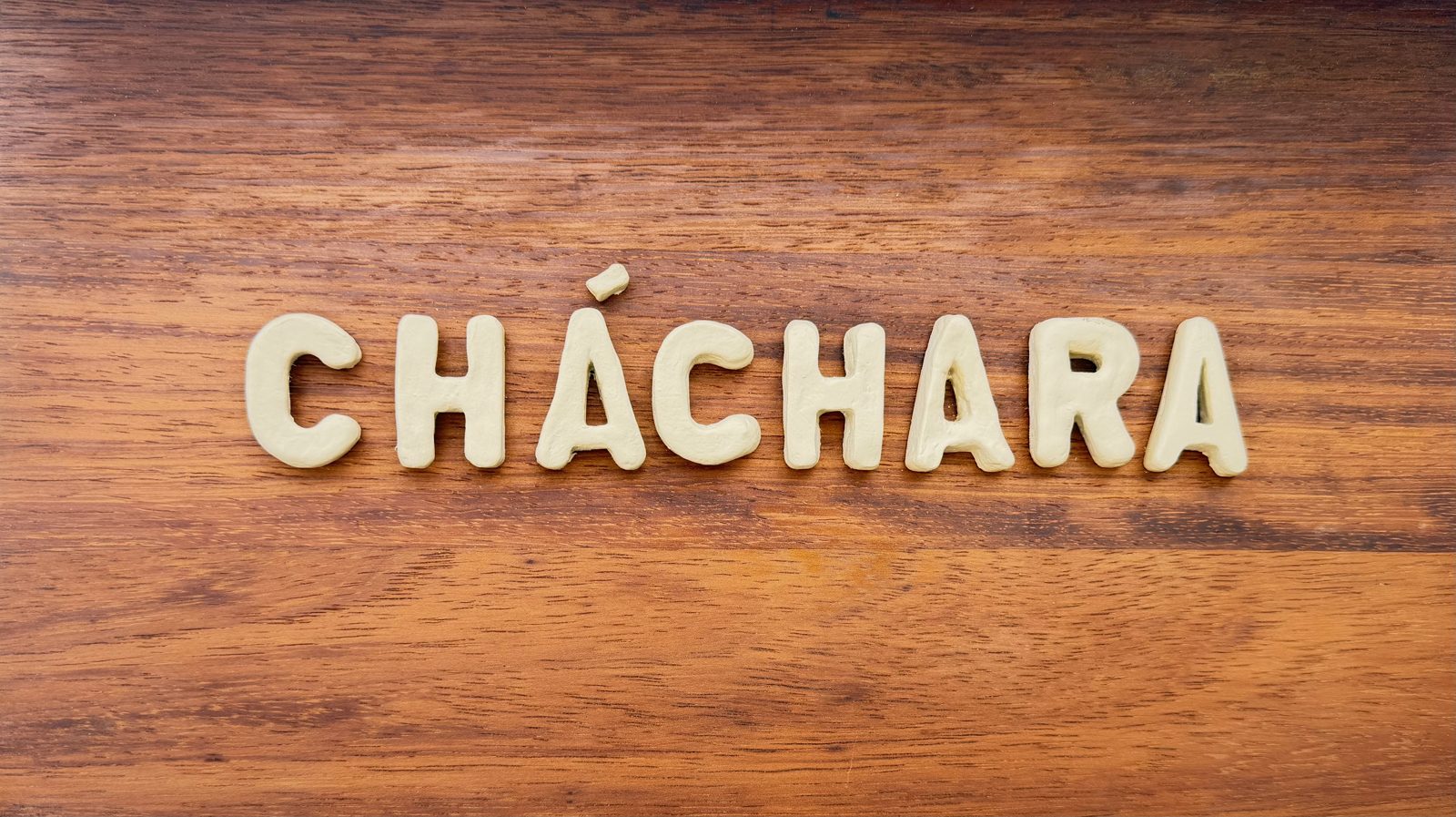 The Cháchara sign — handmade letters on oiled wood